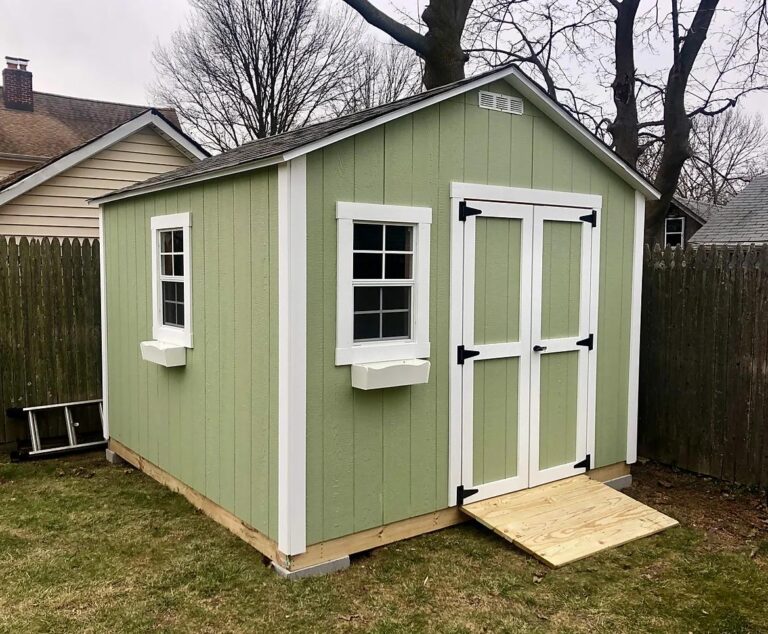 green and white garden shed with a ramp