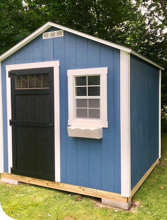 blue shed with brown door and white window frames